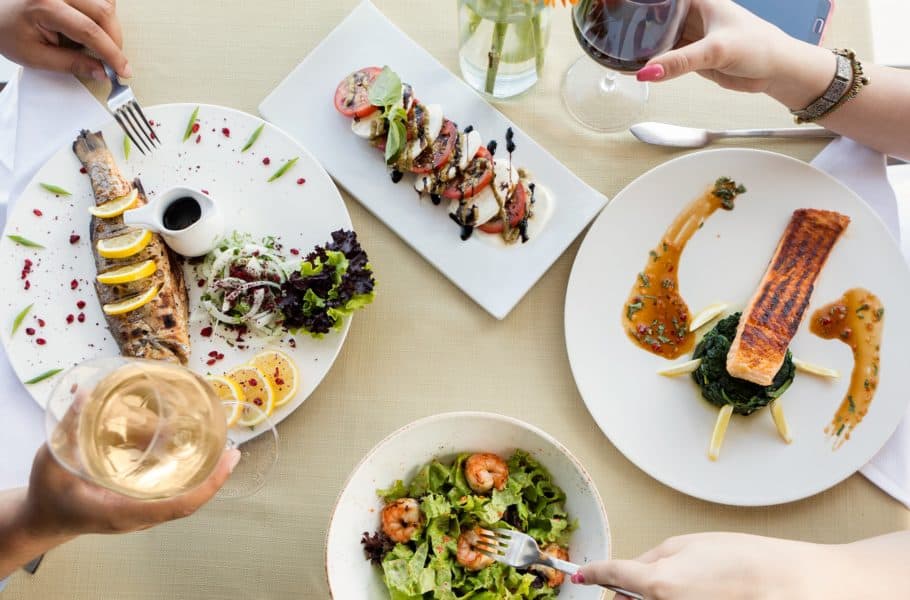 Couple eating a fish meal with lemon and white wine by Farhad Ibrahimzade - Unsplash
