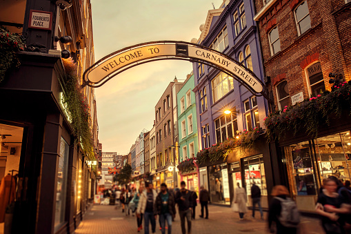 Defocused people walking near the shops and restaurants of Carnaby Street in London