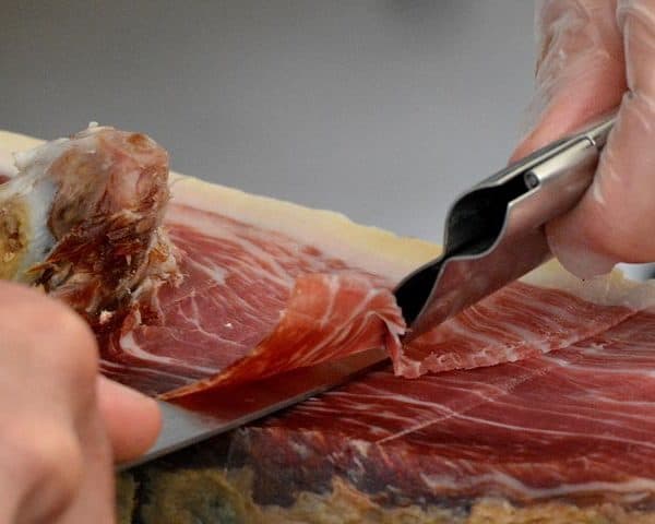 Butcher slicing Spanish Jamón